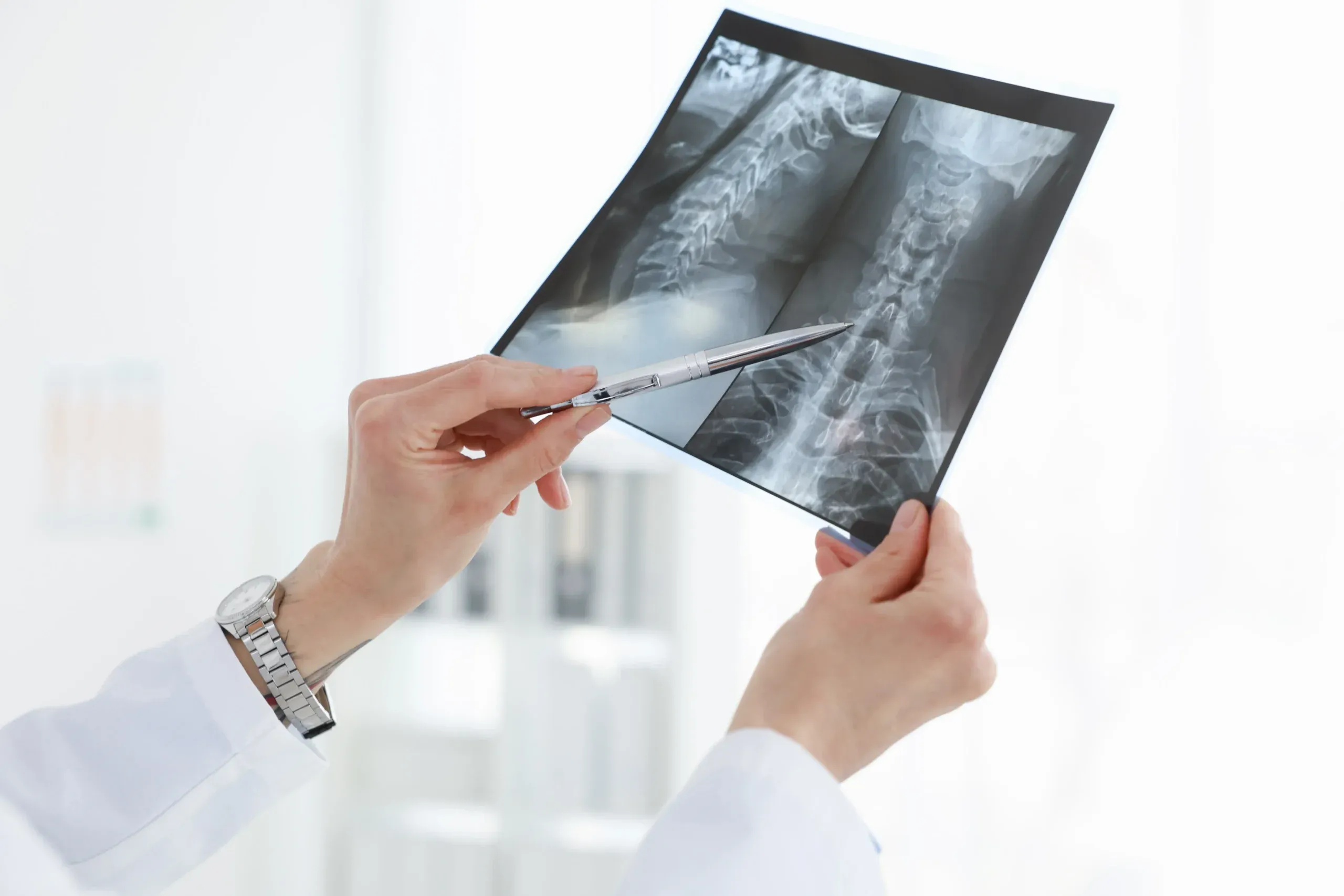 Arzt zeigt mit einem Stift auf eine Röntgenaufnahme zur Erklärung radiologischer Untersuchungen